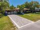 Beautiful exterior view showcasing a brick driveway, well-maintained lawn, and charming home with unique architectural details at 815 Kentucky Ave, St Cloud, FL 34769