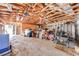 Cluttered garage with exposed ceiling and beams, housing various tools and equipment, presenting ample storage potential at 815 Kentucky Ave, St Cloud, FL 34769