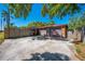 Exterior view of a two-car garage with fenced yard surrounded by trees and sunny skies at 815 Kentucky Ave, St Cloud, FL 34769