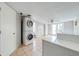 Bright laundry room boasts a stacked washer and dryer and tiled floors offering convenience and functionality at 815 Kentucky Ave, St Cloud, FL 34769