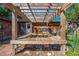Pergola-covered outdoor space creates a comfortable area with seating and views of the backyard at 815 Kentucky Ave, St Cloud, FL 34769