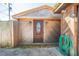 Wood shed entrance with detailed door, and security camera, with landscaping visible at 815 Kentucky Ave, St Cloud, FL 34769