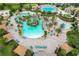 Expansive aerial view of resort-style community pool area with palm trees, lounge chairs, and water features at 8817 Cruden Bay Ct, Davenport, FL 33896