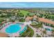 Community clubhouse and pool area surrounded by lush landscaping, creating a vacation-like atmosphere at 8817 Cruden Bay Ct, Davenport, FL 33896