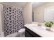 Modern bathroom featuring a shower with a black and white geometric curtain, toilet and single sink at 8817 Cruden Bay Ct, Davenport, FL 33896