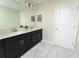 Elegant bathroom with double vanity, dark wood cabinets, modern fixtures, and stylish marble-look floors at 8817 Cruden Bay Ct, Davenport, FL 33896
