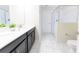 Bright bathroom featuring a double vanity, white countertops, modern fixtures, and a glass-enclosed shower at 8817 Cruden Bay Ct, Davenport, FL 33896