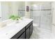 Elegant bathroom with double sinks, marble countertops, and a glass-enclosed shower at 8817 Cruden Bay Ct, Davenport, FL 33896