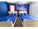 Charming bedroom featuring twin beds, vibrant blue walls, and a whimsical Disney-themed mural at 8817 Cruden Bay Ct, Davenport, FL 33896