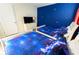 A cozy bedroom featuring two twin beds, a dresser with a TV, and whimsical star decorations on the blue wall at 8817 Cruden Bay Ct, Davenport, FL 33896
