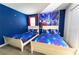 Disney themed bedroom with two beds, blue walls with starry accents, and cartoon character wall art at 8817 Cruden Bay Ct, Davenport, FL 33896