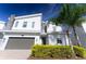 Modern two-story home with gray garage door, decorative stone accents, and green shrubbery at 8817 Cruden Bay Ct, Davenport, FL 33896