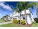 Contemporary two-story home with white exterior, gray accents, and lush palm trees at 8817 Cruden Bay Ct, Davenport, FL 33896