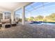 A covered patio area with comfortable seating and a screened-in pool overlooking the golf course at 8817 Cruden Bay Ct, Davenport, FL 33896