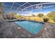 Inviting pool area with a screen enclosure, spa, and views of the surrounding golf course and greenery at 8817 Cruden Bay Ct, Davenport, FL 33896