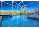Beautiful screened-in pool with a spa, surrounded by lush landscaping and clear blue skies at 8817 Cruden Bay Ct, Davenport, FL 33896