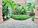 Walkway leading to an elegant courtyard with a variety of lush plants and trees at 911 N Orange Ave # 550, Orlando, FL 32801