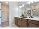 Bathroom with dual sinks, dark cabinets, a large mirror, and tiled floors at 1011 Wisteria Way, Dundee, FL 33838