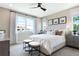 Bright main bedroom featuring large windows, a ceiling fan, and neutral decor at 1011 Wisteria Way, Dundee, FL 33838