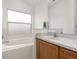 Bathroom with large window over a tub and a bright vanity and mirror at 105 Winchester Ln, Haines City, FL 33844