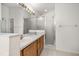 Well-lit bathroom featuring double sinks, a large mirror, and a glass-enclosed shower at 105 Winchester Ln, Haines City, FL 33844