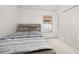 Simple bedroom with carpet flooring, a rustic bed frame, and a view of the exterior through a window at 105 Winchester Ln, Haines City, FL 33844