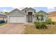 Charming single-story home with a brick driveway, two-car garage, and well-maintained landscaping at 105 Winchester Ln, Haines City, FL 33844