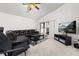 Open living room with dark brown leather sofa, neutral colors and sliding glass doors at 105 Winchester Ln, Haines City, FL 33844