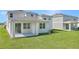 A view of the home's backyard, featuring a covered patio and AC unit at 1107 Olivine Ave, Dundee, FL 33838