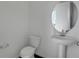 Modern bathroom with pedestal sink and toilet with white walls and fixtures at 1107 Olivine Ave, Dundee, FL 33838