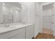 Stylish bathroom featuring dual sinks, quartz countertops, wood-look flooring, and a glass-enclosed shower at 1107 Olivine Ave, Dundee, FL 33838