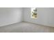 Clean carpeted bedroom with white walls and a window providing natural light at 1107 Olivine Ave, Dundee, FL 33838