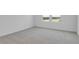 Bright bedroom features neutral carpet, white walls, and a double window for natural light at 1107 Olivine Ave, Dundee, FL 33838