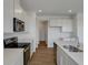 Bright kitchen featuring stainless steel appliances, white cabinets, an island with quartz countertops, and wood-look flooring at 1107 Olivine Ave, Dundee, FL 33838