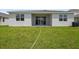 A view of the home's backyard and exterior, surrounded by green grass at 1122 Olivine Ave, Dundee, FL 33838