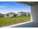 View of a lush backyard with new construction homes in the distance at 1122 Olivine Ave, Dundee, FL 33838