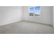 This bedroom offers neutral carpet, a large window, and fresh white paint at 1122 Olivine Ave, Dundee, FL 33838