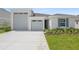 A beautifully landscaped single Gathering home featuring an attached two-car garage and a well manicured lawn at 1122 Olivine Ave, Dundee, FL 33838
