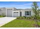 Charming single Gathering home featuring a well manicured lawn, attached two-car garage, and blue shutters at 1122 Olivine Ave, Dundee, FL 33838