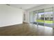 Open-concept living space featuring a large glass sliding door and wood look floors at 1134 Olivine Ave, Dundee, FL 33838