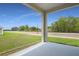Covered porch area looking out at the back lawn and wooded area at 1138 Olivine Ave, Dundee, FL 33838