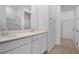 Bathroom featuring double sinks, quartz countertop, walk-in closet and glass enclosed shower at 1138 Olivine Ave, Dundee, FL 33838