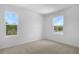 Bedroom with carpeting, two windows with exterior view, and electrical outlets at 1138 Olivine Ave, Dundee, FL 33838