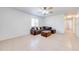 Bright living room featuring neutral tile flooring, a ceiling fan, and a comfortable, large, brown couch at 1211 Shawnee Dr, Kissimmee, FL 34744