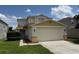 Inviting two-story home featuring a large two-car garage, well-maintained lawn, and colorful exterior paint scheme at 133 Rona Ln, Davenport, FL 33897