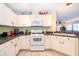 A well-equipped kitchen with white cabinets and appliances, offering functionality and ample storage space at 133 Rona Ln, Davenport, FL 33897