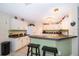 Well-lit kitchen with white cabinetry, functional layout, and counter seating at 133 Rona Ln, Davenport, FL 33897