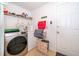 Functional laundry room featuring a modern washer/dryer, storage shelves, and convenient exterior access at 133 Rona Ln, Davenport, FL 33897