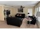 Neutral living room featuring 3 black sofas, a ceiling fan, carpet, and bright windows at 133 Rona Ln, Davenport, FL 33897
