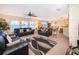 Spacious living room featuring leather sofas, ceiling fan, access to the dining area, and natural lighting at 133 Rona Ln, Davenport, FL 33897